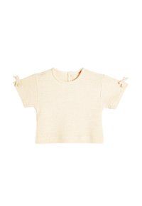 Kortärmad krämfärgad t-shirt, texturerat stickat material, rund halsringning, knäppning bak, med små band på ärmarna som detalj.