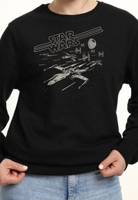Black sweatshirt featuring a silkscreen graphic of a spaceship and "STAR WARS" text in bold letters, set against a galaxy background.