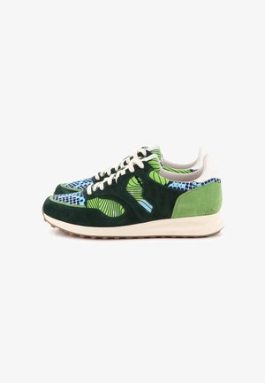 Paire de baskets basses en daim vert, avec des motifs géométriques bleus, des lacets blancs et des semelles beiges, vues de profil sur un fond blanc.