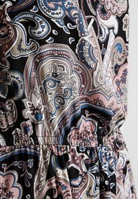 Robe à manche courte en tissu léger présentant un fond noir avec des motifs paisley complexes en rose, bleu et crème. Détail de taille élastique.