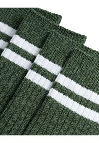 Zöld bordázott zoknik fehér csíkokkal, textúrált kötött anyaggal és hajtott felső résszel a biztonságos illeszkedés érdekében. Alkalmas mindennapi viseletre.