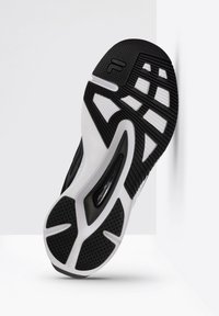 Suola di scarpa atletica in bianco e nero con gomma testurizzata, motivi a zigzag e dettagli di ammortizzazione ad aria. Design con punta arrotondata e tacco piatto.