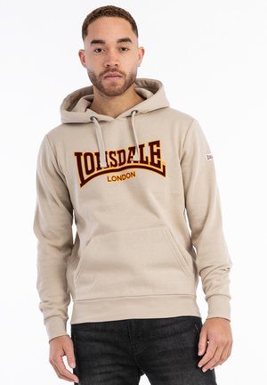 Sudadera con capucha beige y un bolsillo frontal, que presenta un gran logotipo naranja y rojo que dice "Lonsdale London" en el pecho.