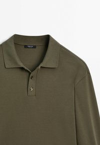 Polo à manches longues vert olive avec deux boutons à l'avant et col côtelé, étiquette Massimo Dutti, posé à plat sur un fond blanc.