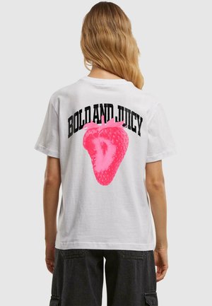 Hvit bomull t-skjorte med en stor rosa jordbærgrafikk på baksiden, med "BOLD AND JUICY" trykt i svart over.
