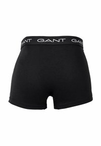 Zwarte katoenen boxershorts met een witte logo-band, een gladde textuur en een aansluitend ontwerp. Geen extra patronen of hardware.