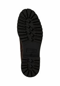 Semelle en caoutchouc noir avec des motifs profonds pour une traction optimale, présentant un design arrondi et une empreinte de logo ; surface texturée pour améliorer l'adhérence.