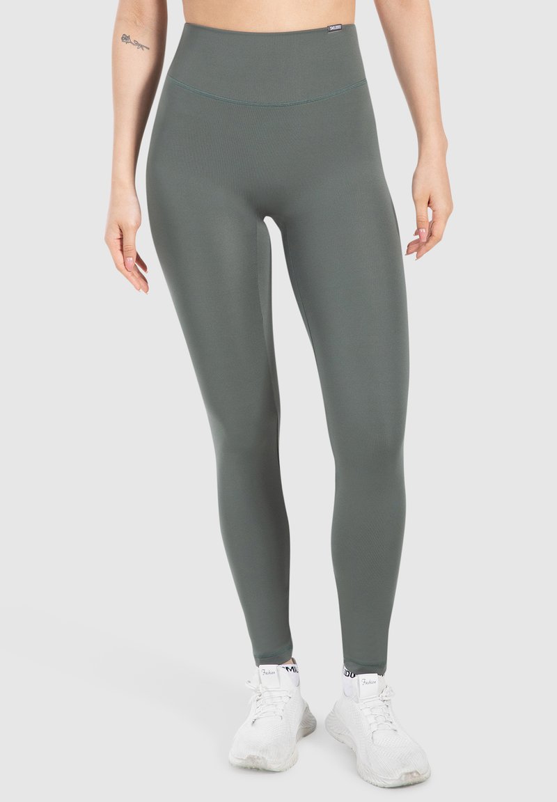 Leggings a vita alta e aderenti in verde tenue, realizzati in materiale elasticizzato. Presentano una superficie liscia e dettagli di cucitura discreti.