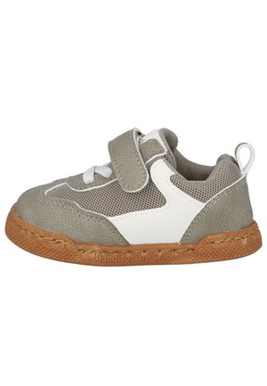 Zapatilla gris y blanca con tela de malla, suela de goma y correa de Velcro. Presenta un upper texturizado y costuras decorativas. Marca grabada en la suela.