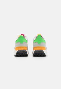 Baskets multicolores avec un dessus gris, des accents verts et un talon orange. Elles disposent d'une semelle texturée et de détails vifs contrastants.