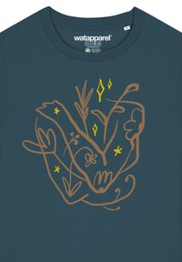 T-shirt turquoise avec un dessin en ligne brun de mains et de plantes, rehaussé de touches jaunes, sur un tissu doux. Encolure ras du cou et coupe décontractée.