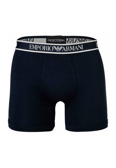 Temno modri bokserice iz mehkega bombaža, ki imajo elastični pas z logotipom "Emporio Armani" v belih in sivo obarvanih odtenkih.