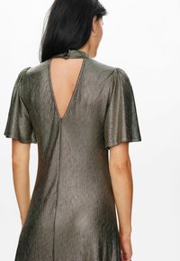 Metallic grey dress featuring short flutter sleeves, a deep V-back, and textured pattern, highlighting a smooth, shimmering surface.