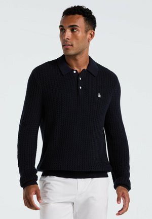 Navyblauwe gebreide polo trui met een textuurpatroon, met een kraag met knopen en lange mouwen. Heeft een klein logo op de borst.