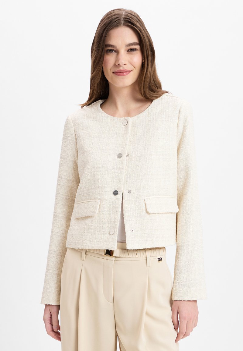 Crème cropped jack gemaakt van textuurstof, met zilveren knopen en twee voorkoppelzakken, gecombineerd met beige hoge taille broek.
