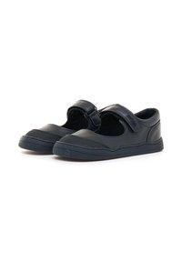 Zapatos de cuero negro con punta redondeada, una correa de velcro y acentos texturizados en la parte superior y la suela. Diseño de perfil bajo, adecuado para el uso casual.