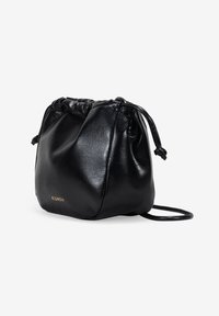 Bolsa de drawstring de imitación cuero negra con una textura suave, forma redondeada y una correa delgada para el hombro. Presenta un sutil logo dorado en el costado.