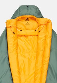 Grüne isolierte Jacke mit einem hellgelben Innenfutter, die eine Kapuze, Zugbänder und eine glatte Textur aufweist. Ein großes Größenetikett ist sichtbar.
