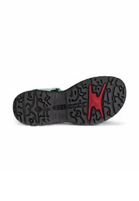 Black rubber shoe sole with textured tread patterns, featuring a red accent in a cross shape near the center.