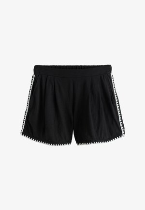 Czarne casualowe spodenki z elastycznym pasem i białym zygzakowatym obszyciem wzdłuż boków i dołu, wykonane z miękkiego materiału.