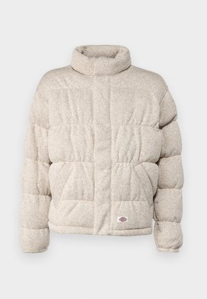 Zateplená bunda vo svetlo béžovej tkanine s vysokým golierom, s prešívaným dizajnom a malou nášivkou loga na leme.