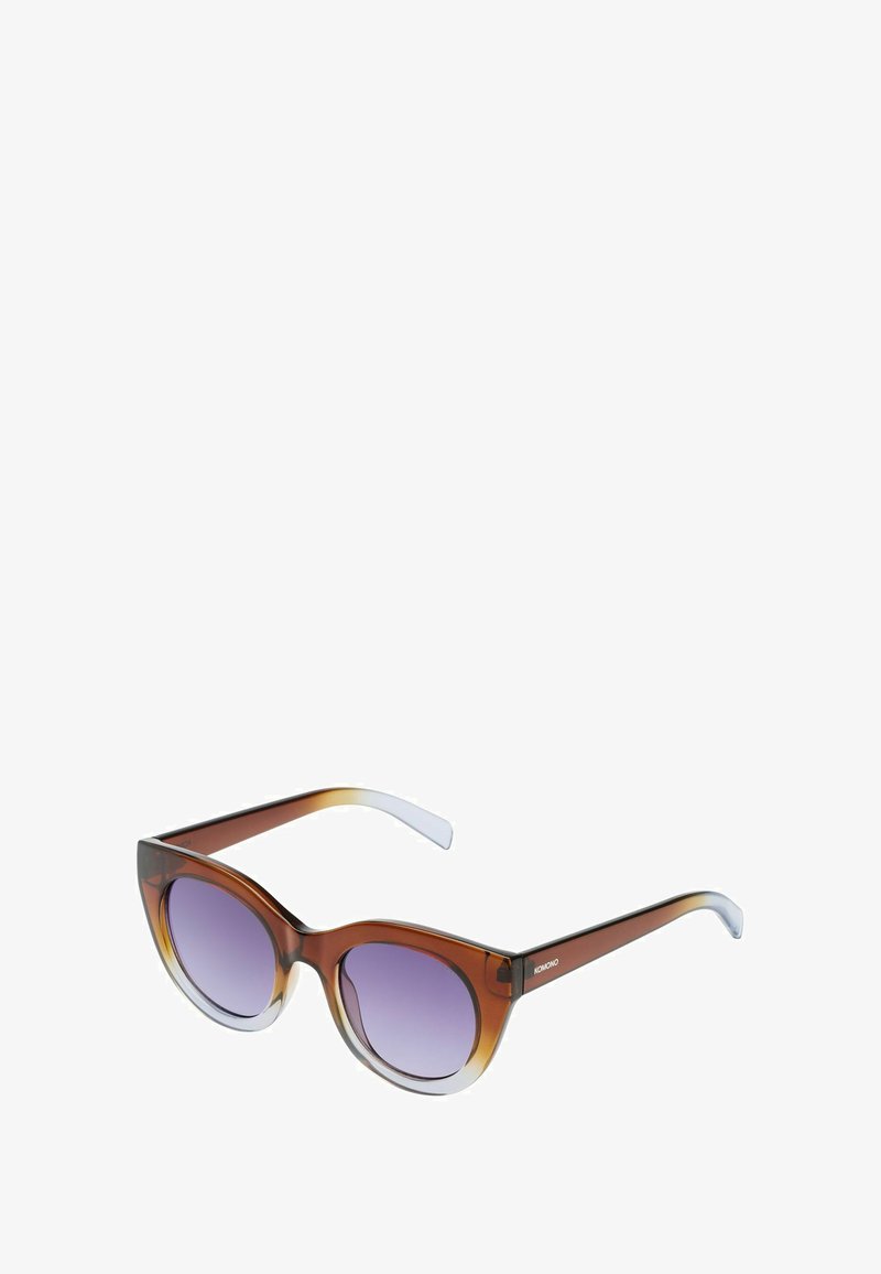 Cat-eye zonnebril met een bruine gradient montuur, paarse getinte lenzen en klare pootjes. Het ontwerp heeft een soepele, glanzende afwerking.