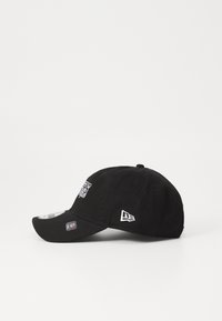 Gorra negra de algodón, con visera curveada, logo bordado en la parte delantera y una pequeña etiqueta de logo en el lateral. Diseño de ajuste estándar.