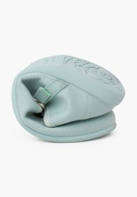 Borsa rotonda di un verde menta chiaro realizzata in materiale morbido, con una superficie texturizzata e un gancio metallico attaccato per la chiusura.