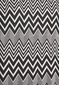 Schwarz-weißer Zickzackmusterstoff mit abwechselnden dicken und dünnen Chevronstreifen, die ein geometrisches Design bilden.