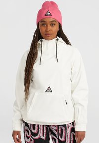 Witte pullover jack met een voorzak, verstelbare capuchon en zwarte koordjes. Combinatie met gemusterde zwarte broek en een roze geribbelde muts.