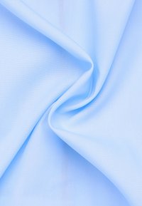 Tessuto azzurro chiaro con una consistenza liscia, che mostra sottili motivi di tessitura diagonale e pieghe delicatamente drappeggiate, indicando un materiale leggero.