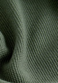Tessuto verde strutturato con un motivo a coste; spessore medio e un aspetto morbido e lavorato a maglia.