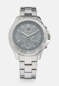 Orologio in acciaio inossidabile argento con quadrante grigio, tre sotto-quadranti e una lunetta lucida. Le caratteristiche includono indici delle ore marcati e un bracciale con chiusura.