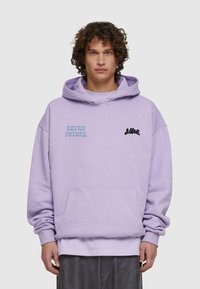 Felpa viola con tasca frontale, presenta il logo "RETRO FUTURE" in azzurro chiaro e nero sul petto. Vestibilità ampia con cappuccio regolabile.