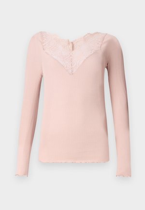Light pink long-sleeve top with ribbed texture, lace neckline, and scalloped edges. Simple design, fitted shape, and soft fabric.