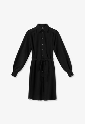 Zwarte jurk met lange mouwen, kraag, knoopsluiting aan de voorkant, verstelbare tailleband en omgeslagen mouwen, afgebeeld op een witte achtergrond.