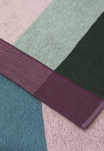 Tissu multicolore avec un tissage texturé. Il comporte des sections rose, vert, vert foncé et teal, accentuées par une bordure bordeaux.