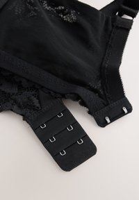 Sort blonde-bh med gennemsigtig mesh, indviklet blonddetaljering, justerbare stropper og lukning med krog-og-øje med flere indstillinger.