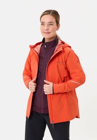 Giacca impermeabile arancione brillante con cappuccio, dotata di tasche con zip, interno foderato e dettagli riflettenti per la visibilità.