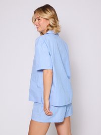 Hellblaue und weiße gestreifte Pyjama-Set, bestehend aus einem kurzärmeligen Hemd mit Knopfleiste und passenden Shorts, aus weichem Baumwollstoff gefertigt.