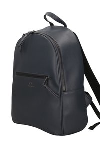 Zaino in ecopelle grigio scuro con forma arrotondata, tasca frontale con zip e spallacci neri regolabili. Dettaglio del logo dorato visibile.