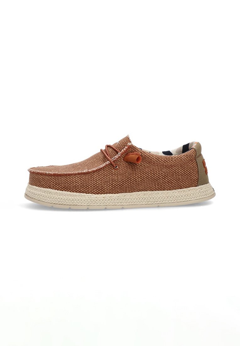 Zapato marrón trenzado de tipo slip-on con un upper texturizado, suela contrastante en color marrón claro, detalle decorativo de nudo y un forro interior con estampado.