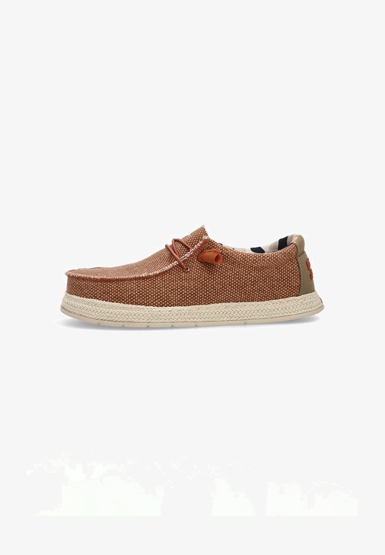 Zapato marrón trenzado de tipo slip-on con un upper texturizado, suela contrastante en color marrón claro, detalle decorativo de nudo y un forro interior con estampado.