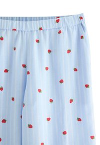 Ανοιχτό μπλε σορτς πυτζάμας με λευκές κάθετες ρίγες, διακοσμημένα με κόκκινα σχέδια φράουλας, ελαστική μέση και απαλό ύφασμα.