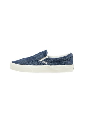 Blå slip-on sneaker med hvid sål og Vans-logo på siden, med et tekstureret vævet stofmønster.