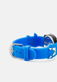 Blauer Silikon-Uhrenarmband mit einem Cartoon-Charakter und gelben Akzenten. Edelstahlverschluss und schwarzes Zifferblatt sichtbar.