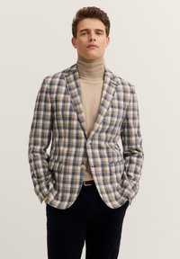 Blazer in einem hellbraunen und blauen Karomuster, aus strukturiertem Stoff mit tailliertem Schnitt, mit Reverskragen und zwei vorderen Taschen.