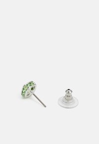 Orecchini a perno con cristalli verdi, dotati di retro in metallo argentato e clutch back in plastica trasparente. Forma esagonale con molteplici sfaccettature.