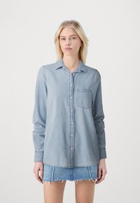 Lichtblauwe denim shirt met lange mouwen, knoopsluiting, een kraag en een borstzak. Heeft een losse pasvorm en een zachte textuur.