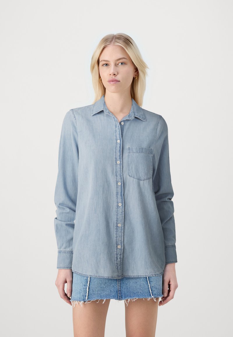 Lichtblauwe denim shirt met lange mouwen, knoopsluiting, een kraag en een borstzak. Heeft een losse pasvorm en een zachte textuur.